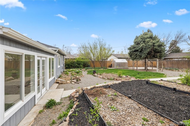 view of yard featuring a fenced backyard and a garden