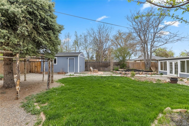 view of yard featuring french doors, an outbuilding, and a fenced backyard