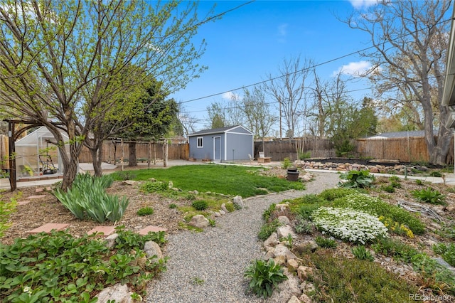view of yard featuring a fenced backyard, an outbuilding, and an exterior structure