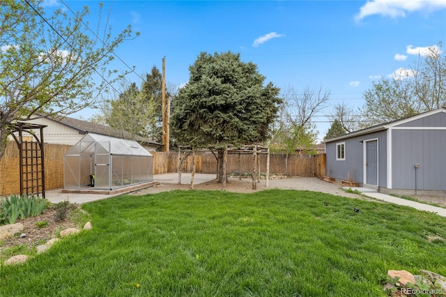 view of yard featuring an exterior structure, an outbuilding, and a fenced backyard