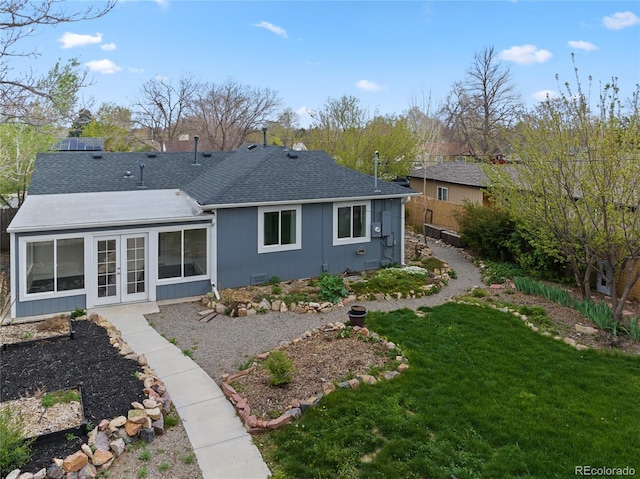 back of property featuring roof with shingles, fence, a yard, and french doors