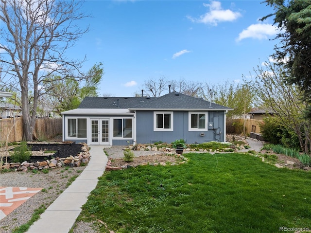 back of house with french doors, a lawn, a shingled roof, and fence