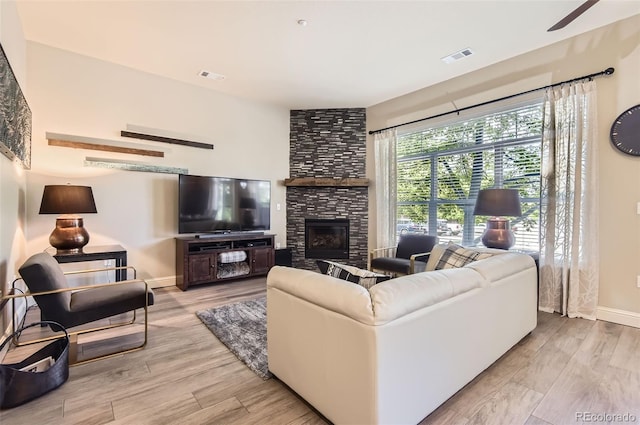 5401 S Park Terrace Ave Unit 109A, Greenwood Village, CO 80111 - living area featuring wood finished floors, baseboards, a large fireplace, and a ceiling fan