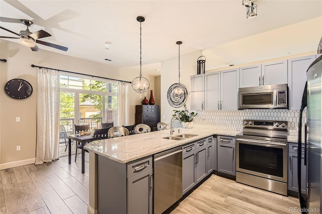 5401 S Park Terrace Ave Unit 109A, Greenwood Village, CO 80111 - kitchen with appliances with stainless steel finishes, a sink, gray cabinetry, tasteful backsplash, and a peninsula