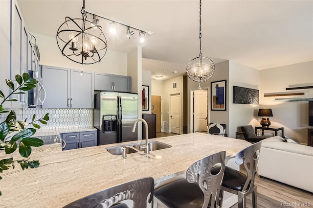 5401 S Park Terrace Ave Unit 109A, Greenwood Village, CO 80111 - kitchen with appliances with stainless steel finishes, a sink, light stone counters, a peninsula, and hanging light fixtures