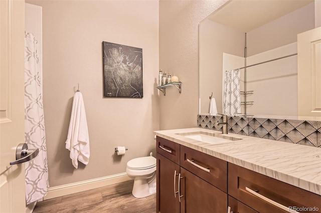 5401 S Park Terrace Ave Unit 109A, Greenwood Village, CO 80111 - bathroom with wood finished floors, tasteful backsplash, baseboards, toilet, and vanity