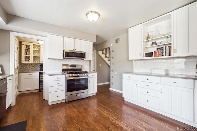 kitchen with decorative backsplash, white cabinets, appliances with stainless steel finishes, and wine cooler
