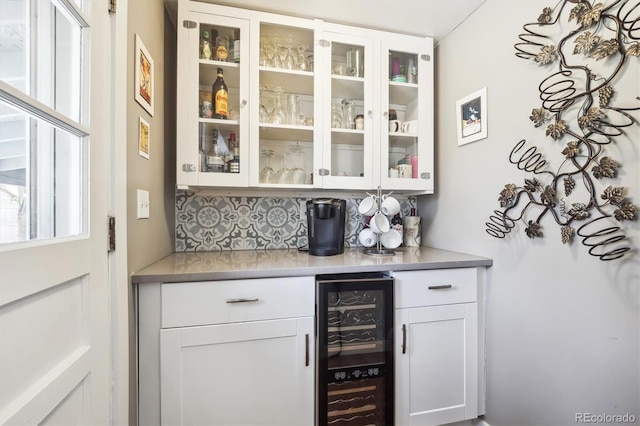 bar featuring decorative backsplash, a bar, and wine cooler