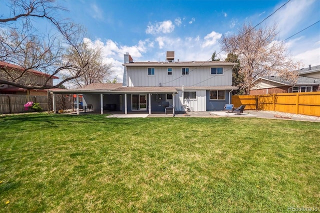 rear view of property featuring board and batten siding, a chimney, a fenced backyard, and a patio area