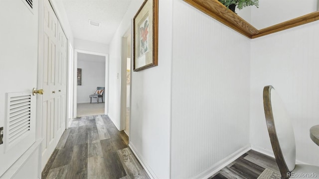 hallway featuring a textured ceiling and dark hardwood / wood-style flooring