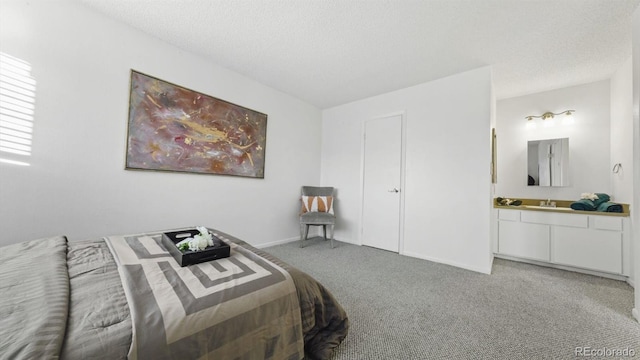 carpeted bedroom featuring ensuite bathroom, sink, and a textured ceiling