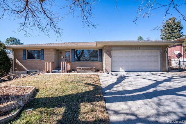 view of front of home with brick siding, an attached garage, fence, driveway, and a front lawn