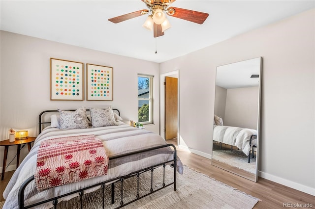 bedroom featuring a ceiling fan, baseboards, and wood finished floors