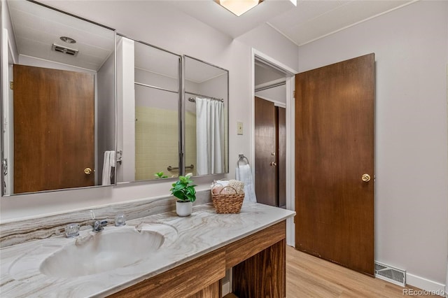 full bathroom with wood finished floors, vanity, visible vents, and a shower with curtain