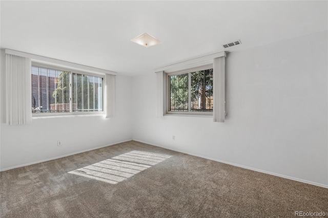 carpeted spare room featuring visible vents