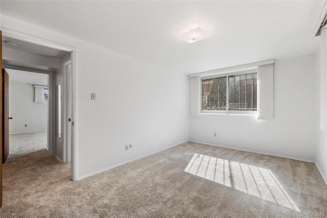 spare room featuring carpet and baseboards