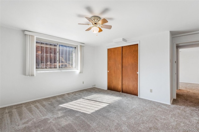 unfurnished bedroom with ceiling fan, a closet, carpet, and baseboards