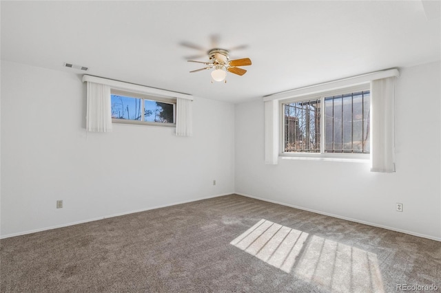 carpeted spare room with ceiling fan and visible vents