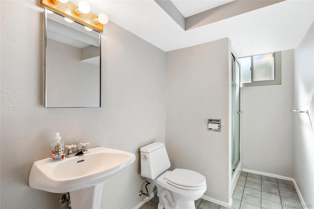 full bathroom with toilet, a stall shower, a sink, tile patterned flooring, and baseboards