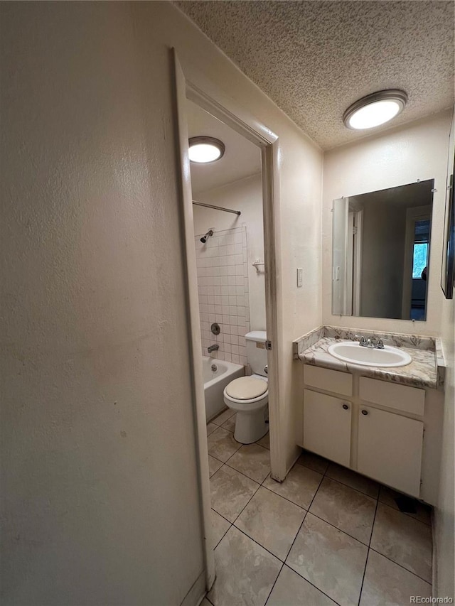 full bathroom with vanity, a textured ceiling, tiled shower / bath, tile patterned flooring, and toilet