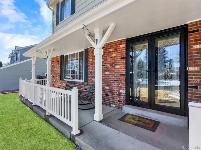 7631 Oak St, Arvada, CO 80005 - property entrance with covered porch, french doors, and brick siding