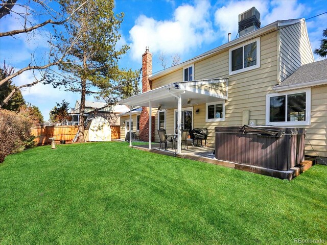 7631 Oak St, Arvada, CO 80005 - back of house featuring a chimney, a fenced backyard, a shed, and a hot tub