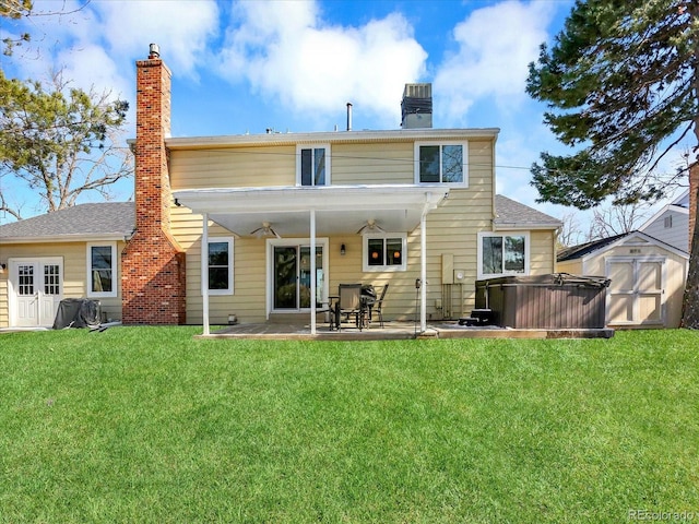 7631 Oak St, Arvada, CO 80005 - rear view of house with a chimney, a storage shed, a patio area, ceiling fan, and a yard