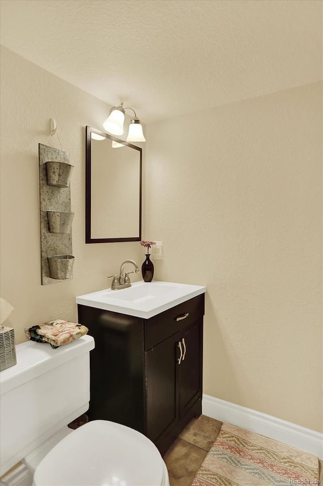 7631 Oak St, Arvada, CO 80005 - half bath featuring vanity, tile patterned floors, and a textured ceiling
