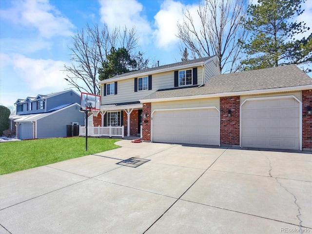 7631 Oak St, Arvada, CO 80005 - traditional-style home featuring a porch, brick siding, an attached garage, driveway, and a front lawn