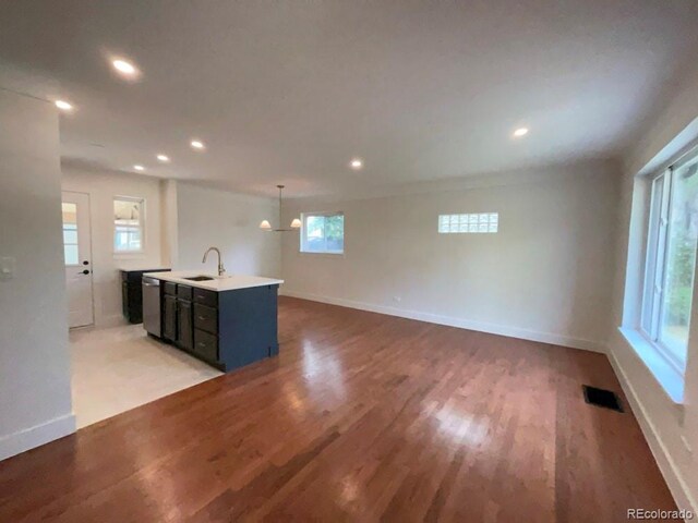 unfurnished living room with sink, light hardwood / wood-style flooring, and plenty of natural light