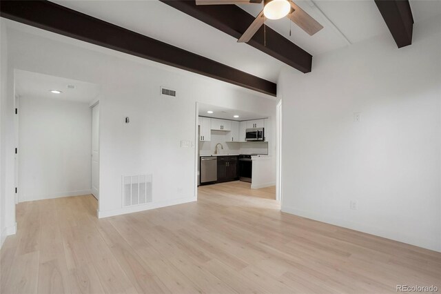 unfurnished living room featuring beamed ceiling, ceiling fan, sink, and light hardwood / wood-style flooring