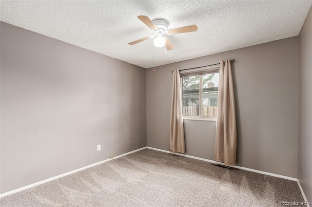 carpeted spare room featuring a textured ceiling, baseboards, and a ceiling fan