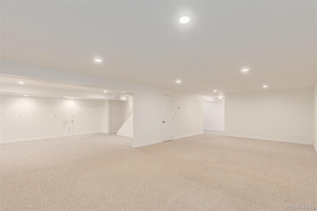 finished below grade area with light carpet, baseboards, and recessed lighting