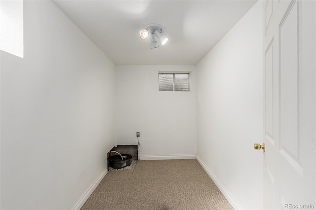 spare room with baseboards and light colored carpet