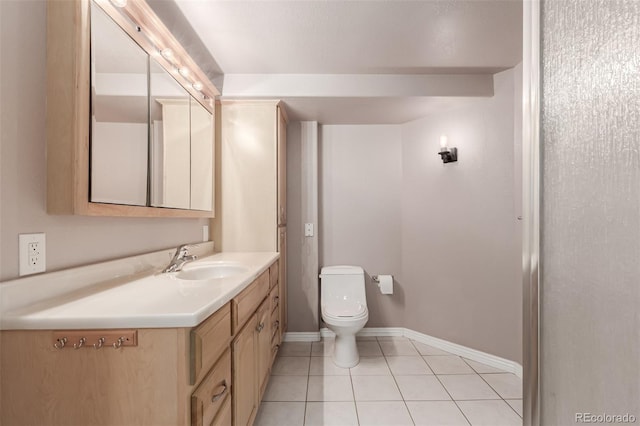 bathroom featuring toilet, vanity, baseboards, and tile patterned floors