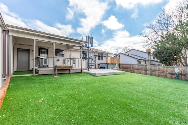 view of yard with fence, a deck, and a jacuzzi