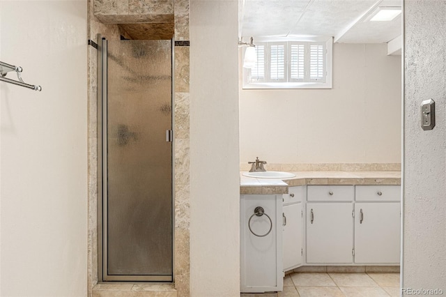 bathroom featuring vanity, a shower with shower door, tile patterned floors, and a textured ceiling