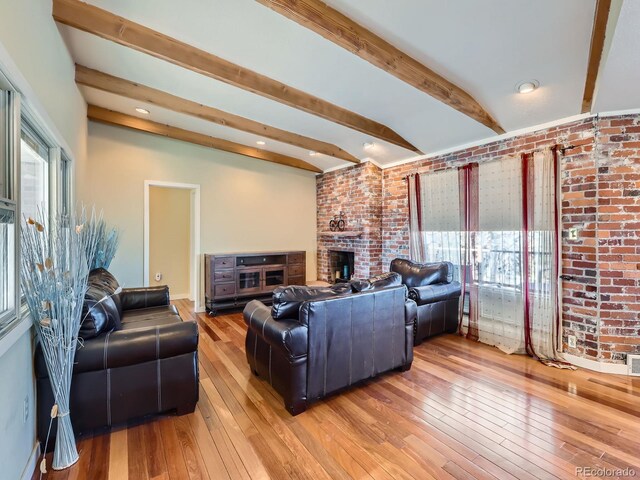 living room featuring hardwood / wood-style flooring, brick wall, and lofted ceiling with beams