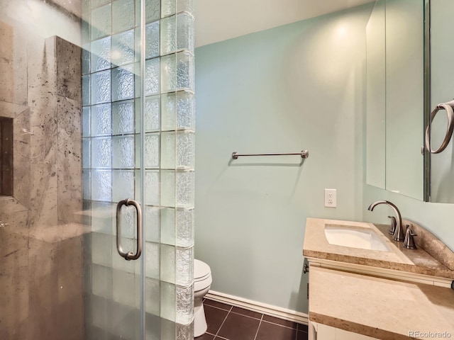 bathroom featuring toilet, tile patterned flooring, walk in shower, and vanity