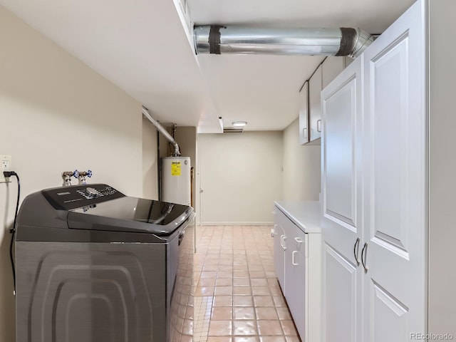 washroom with cabinets, light tile patterned floors, gas water heater, and washing machine and clothes dryer