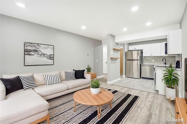 living room featuring sink and light hardwood / wood-style floors