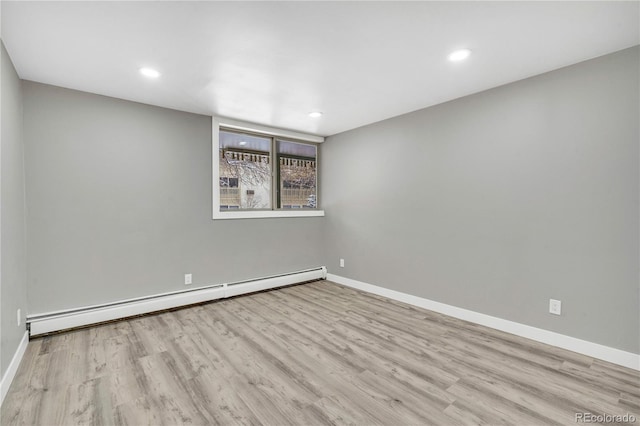 spare room with a baseboard radiator and light hardwood / wood-style floors