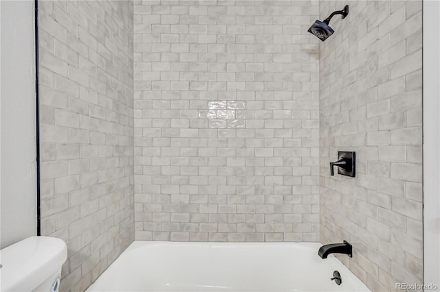 bathroom with tiled shower / bath and toilet