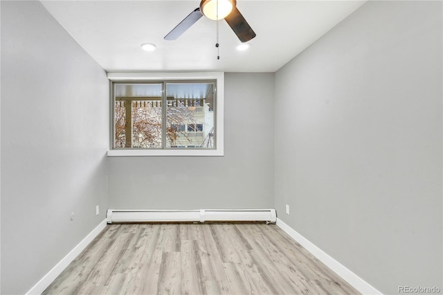 unfurnished room featuring ceiling fan, light wood-type flooring, and a baseboard heating unit