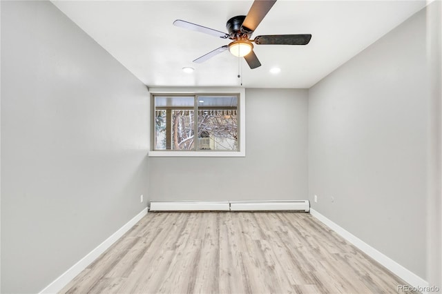 spare room featuring light hardwood / wood-style floors, ceiling fan, and a baseboard heating unit