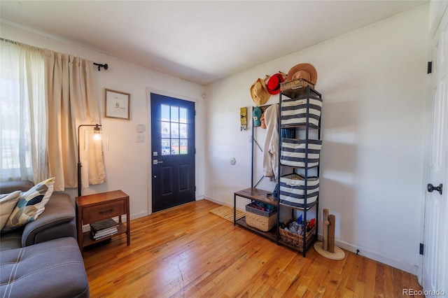 foyer entrance with baseboards and light wood-style flooring