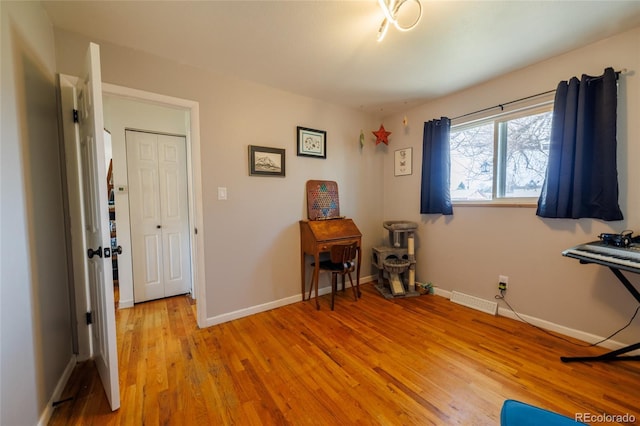 misc room featuring baseboards, visible vents, and light wood finished floors