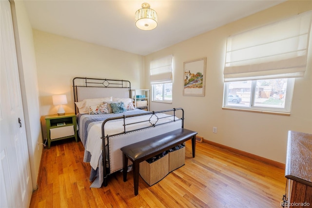 bedroom with light wood-style floors and baseboards