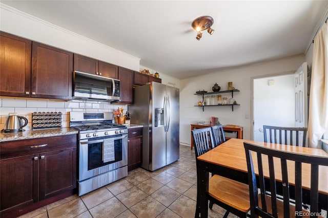 kitchen featuring light stone counters, decorative backsplash, dark brown cabinets, and stainless steel appliances