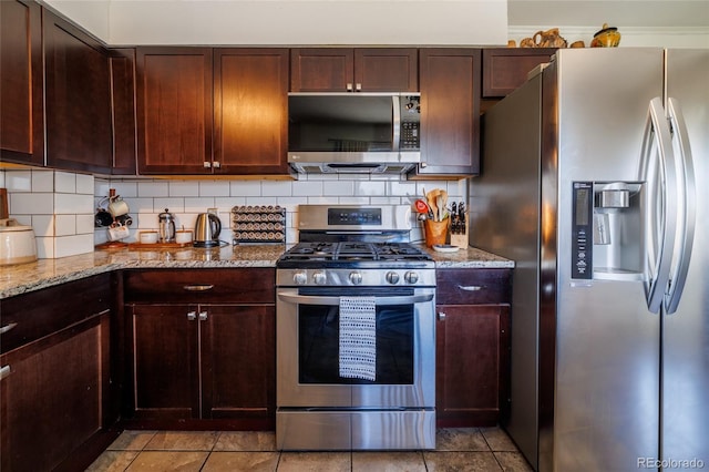 kitchen with light stone counters, tasteful backsplash, and stainless steel appliances